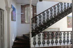 een trap met zwarte relingen in een huis bij Hotel Florita in Jacmel