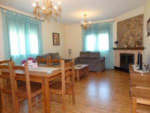 Un comedor y una sala de estar con mesa y sillas. en Casas Rurales La Loma, en Riópar