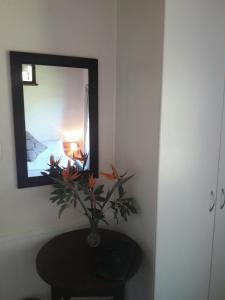 a mirror on a wall with a table and a vase with flowers at Natures Way Farm Cottage in The Crags