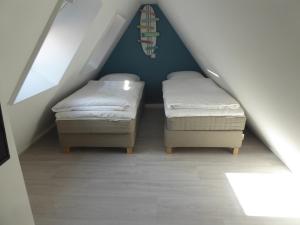 two beds in a room with a attic at Familie beachhuis op de duinen (Duinhuis) in Cadzand +50 photos