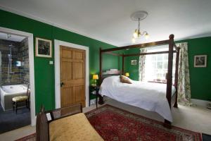 1 dormitorio con paredes verdes, 1 cama y bañera en Plas Gwyn B&B and Holiday Cottage, en Dolgellau