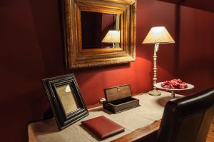 a mirror on a table in a room with a lamp at B&B Het Hof van Petronilla in Gooik