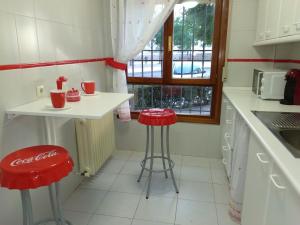une cuisine avec deux tabourets rouges et un comptoir dans l'établissement El Balcón del Tajo, à Tolède