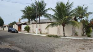a house with two palm trees next to a street at Casa de praia Peruibe in Peruíbe