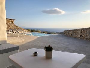 Biały stół na patio z widokiem na ocean w obiekcie Empress Villa w mieście Platis Gialos Mykonos