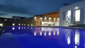 a swimming pool in front of a house at night at Empress Villa in Platis Gialos