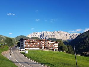 een gebouw aan de kant van een weg met een berg bij Appartamento Dolomiti in Selva di Val Gardena