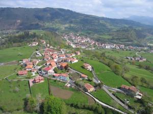 an aerial view of a small town in a green field at Casa El Campu in Infiesto