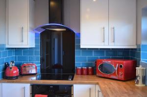 a kitchen with a microwave and a toaster oven at Roman Villa in Bourton on the Water