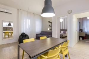 una sala da pranzo e un soggiorno con tavolo e sedie gialle di Verona's Apartment near the Arena a Verona