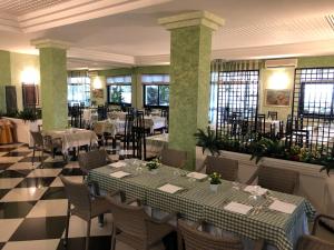 a dining room with tables and chairs and windows at Hotel Ristorante Stellato in Trebisacce