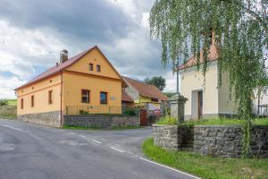 Kamýk nad Vltavou的住宿－Apartmány U kapličky，路旁的黄色房子