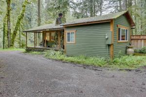 a small green house in the middle of a forest at Eva's Cottage - Romancing the River in Washougal