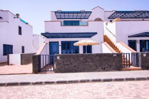 a house with an umbrella in front of it at Casa Playa Honda Kaysurf beach in Playa Honda