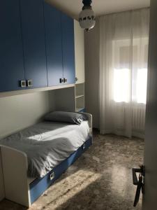 サン・ベネデット・デル・トロントにあるAppartamento Via del Mareのベッドルーム1室(青いキャビネット、窓付)