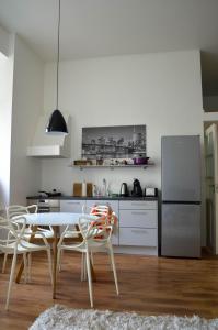 uma cozinha com uma mesa e cadeiras e um frigorífico em City Centre Kreutzwaldi apartment em Taline