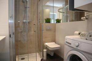 a bathroom with a shower and a washing machine at Sunny Apartment I in Koszalin +15 photos
