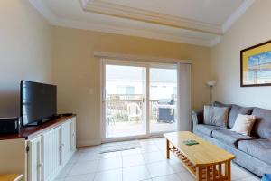 uma sala de estar com um sofá e uma televisão em Rain Dancer Condos em South Padre Island