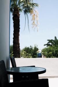 einen Tisch und Stühle neben einer Palme in der Unterkunft Esperida rooms & studios in Amoopi