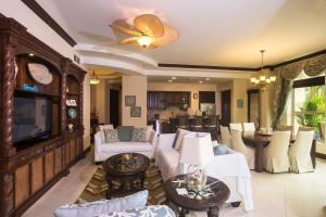 a living room with white furniture and a television at Los Suenos Resort Bella Vista 3F in Herradura