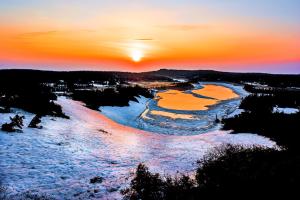 an aerial view of a river at sunset at Pension Entre - deux - Mers in Hachimantai