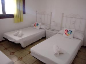twee bedden in een kamer met witte muren bij Chalet Garcia in Deltebre
