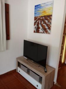 TV de pantalla plana en la parte superior de un centro de entretenimiento de madera en Chalet Garcia en Deltebre