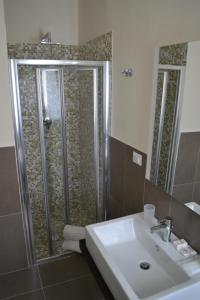 La salle de bains est pourvue d'une douche, d'un lavabo et d'un lavabo. dans l'établissement Hotel Pineta, à Falcade