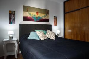 1 dormitorio con 1 cama negra y 2 almohadas en Apartamento Inmejorable Ubicacion en Córdoba
