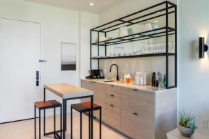 a kitchen with a counter with two stools and a table at Hyde Suites Midtown Miami in Miami