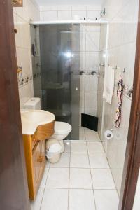 a bathroom with a shower and a toilet and a sink at Pousada São Rafael in Cachoeira Paulista