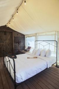 a bed room with a white bedspread and a white canopy at Flying Flags RV Resort & Campground in Buellton