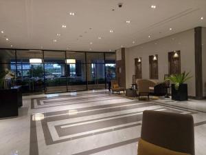 a lobby with chairs and tables in a building at Eighty One Newport Boulevard in Manila
