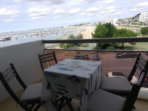 a table and chairs on a balcony with a view of a beach at Le Studio Galliéni vue panoramique face mer a fait peau neuve! in Pornichet