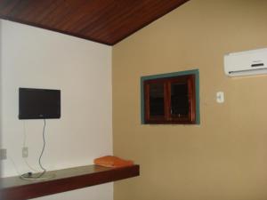 um quarto com uma parede, uma televisão e uma janela em Pousada 7 Mares em Canoa Quebrada