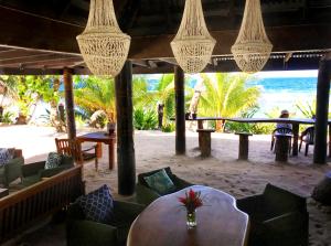 a restaurant with a table and chairs on the beach at Maqai Beach Eco Resort in Qamea