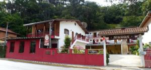 un edificio rojo y blanco con un restaurante en Pousada Nihhon, en Santo Antônio do Pinhal