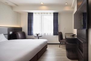 a hotel room with a bed and a desk at Via Inn Nagoya Station Tsubaki-cho in Nagoya