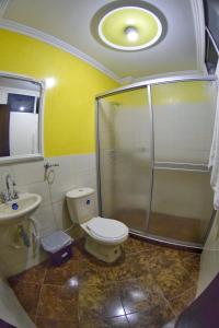 ein Bad mit einer Dusche, einem WC und einem Waschbecken in der Unterkunft Hotel Los Cristales in Pereira