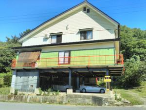饭山市Guest House Hostel yukuru的一栋房子前面停着一辆车