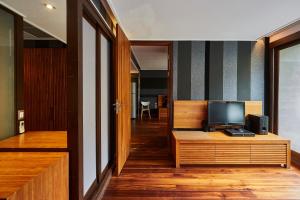 a living room with a television on a wooden cabinet at LUXX Langsuan Hotel - SHA Plus in Bangkok