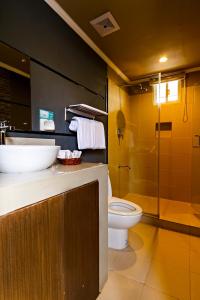 a bathroom with a toilet and a sink and a shower at Vela Terraces Hotel in Coron