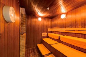 a sauna with benches and a clock on the wall at Cerulean Tower Tokyu Hotel, A Pan Pacific Partner Hotel in Tokyo