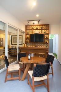 Modern House Surrounded By Nature في ميريدا: غرفة معيشة مع طاولة وكراسي وتلفزيون