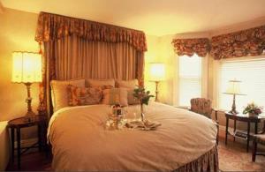 Wynstone Inn في نيوبورت: غرفة نوم بسرير ابيض كبير عليها ورد