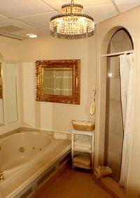 Wynstone Inn في نيوبورت: حمام مع حوض استحمام وثريا