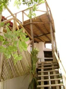um edifício com escadas e um telhado de madeira em Cabañas Aguamarina em Punta Del Diablo