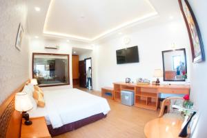 1 dormitorio con cama, escritorio y lavamanos en NỮ HOÀNG HOTEL, en Phan Rang