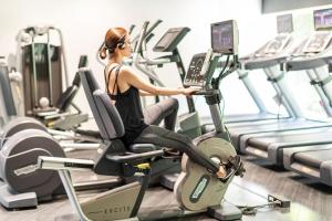 a woman riding on a treadmill in a gym at Cerulean Tower Tokyu Hotel, A Pan Pacific Partner Hotel in Tokyo