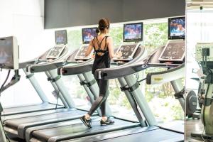 a woman walking on a treadmill in a gym at Cerulean Tower Tokyu Hotel, A Pan Pacific Partner Hotel in Tokyo